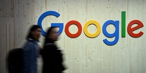 Des personnes marchent a cote d& 39 un logo google