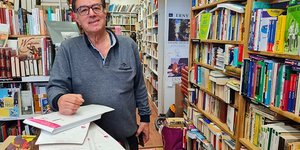 Hamid Kaighobadia prépare des commandes en ligne au milieu de sa librairie atypique