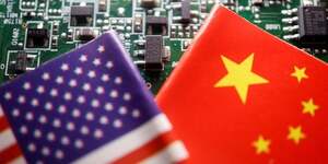 Illustration d'archives des drapeaux de la chine et des etats-unis visibles sur une carte de circuit imprime avec des semi-conducteurs