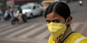 Une policière porte un masque pour se protéger de la pollution de l'air, durant les restrictions temporaires sur les véhicules privés à New Delhi (Inde), le 4 novembre 2019.